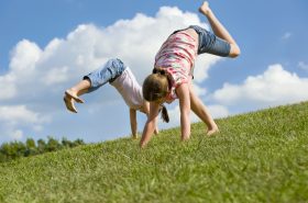 Children playing outside doing cartwheels