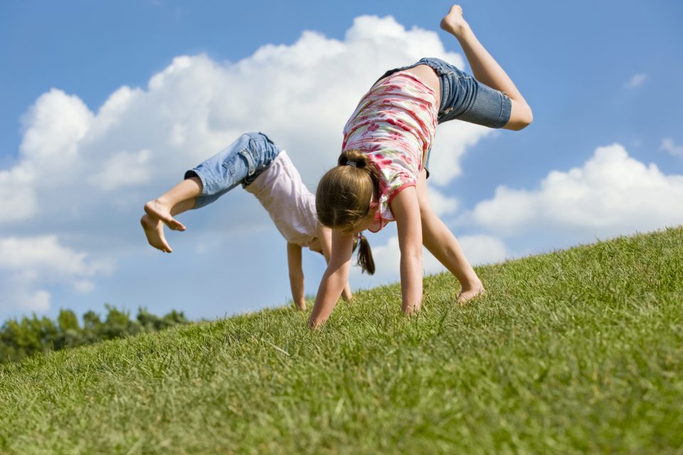 Children playing outside doing cartwheels