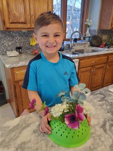 School-age boy making a spring flower craft as he practices his fine-motor skills