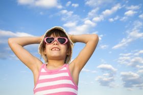 preschool child wearing a sunhat and sunglasses to protect her skin from the summer sun