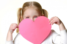 Preschool girl holding a pink Valentine's Day heart card
