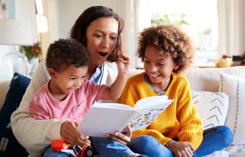 Mother reading a book with her two children on World Book Day