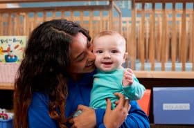 Infant Teacher Hugging Baby