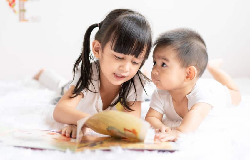 Brother and Sister Reading A Book Together