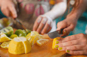 adults cutting up lemons to make lemonade in a bag