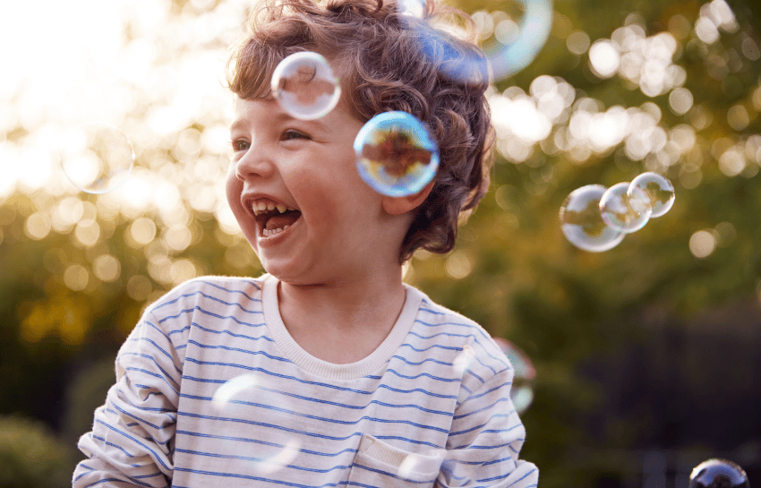 Young boy playing with scented rainbow bubbles