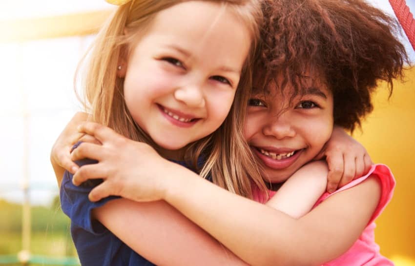 two preschool girls hugging