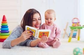 mother reading to her baby on floor