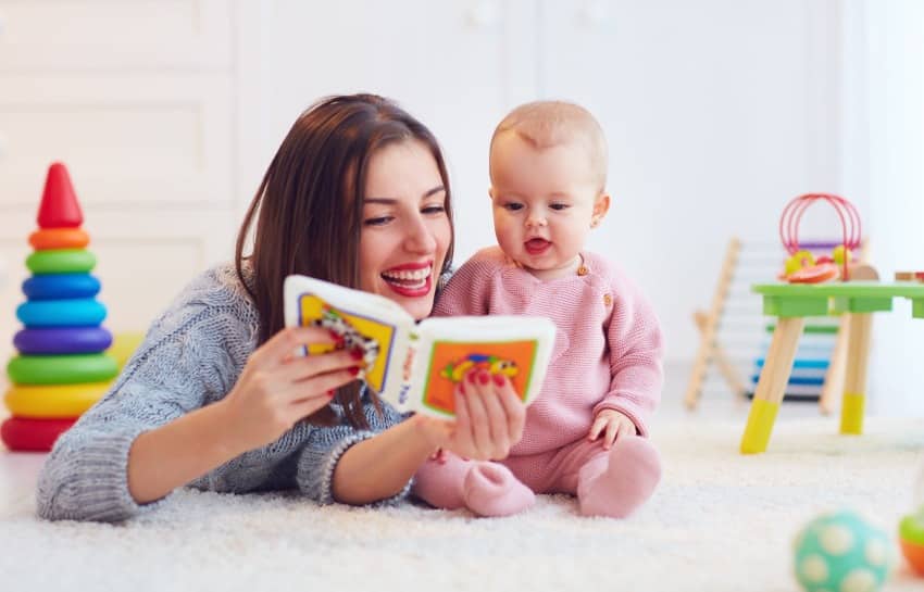 mother reading to her baby on floor