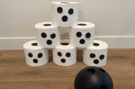 Halloween bowling using toilet paper roll ghosts and a plastic ball