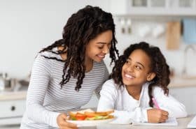 mother giving daughter an after school snack