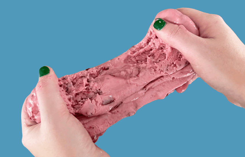 Hands holding cranberry slime