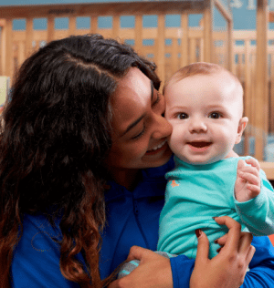 http://Daycare%20teacher%20hugging%20infant