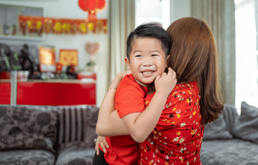 Mother hugging son during Chinese New Year