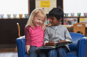 Two young children reading together at daycare