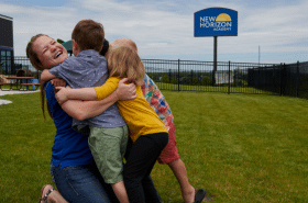 substitute teacher hugging daycare children at New Horizon Academy during work