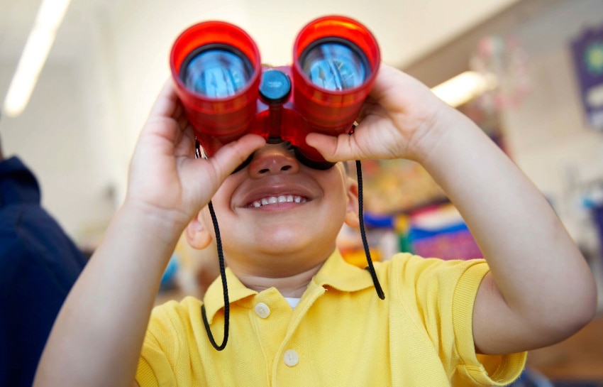 preschool child holding binoculars