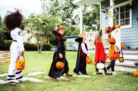 Children following Halloween safety tips while trick-or-treating