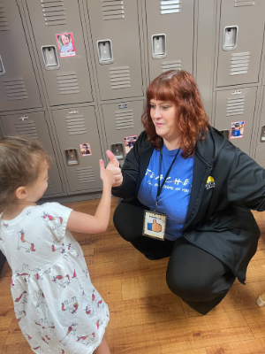 Preschool child choosing a school greeting with daycare teacher