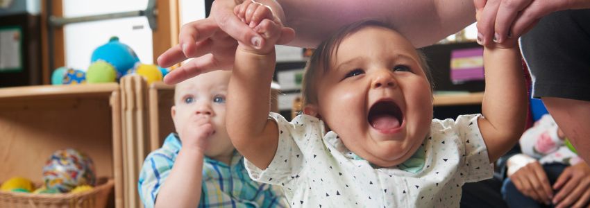 Infant smiling and laughing in infant daycare program at New Horizon Academy