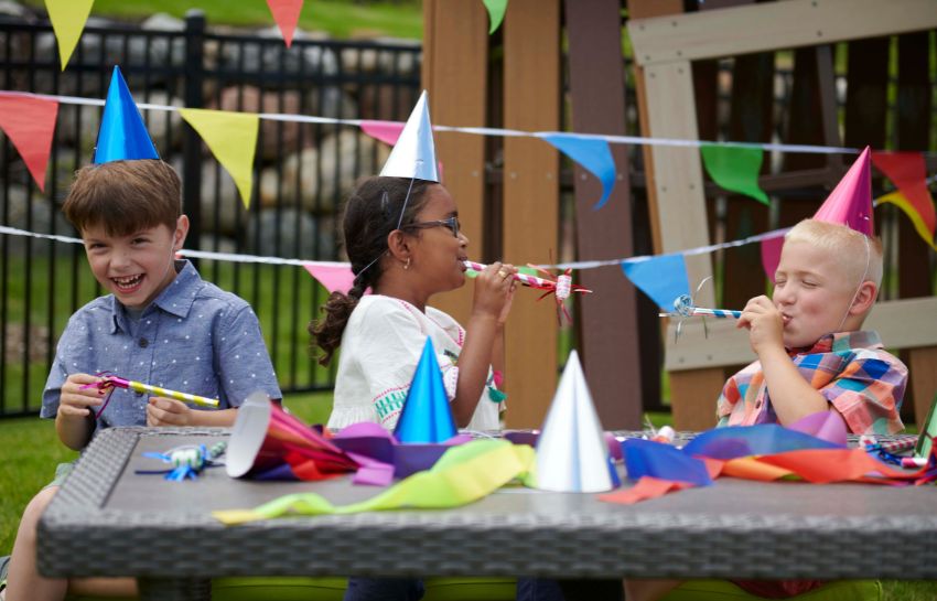 Children with party hats and party blowers celebrating at school