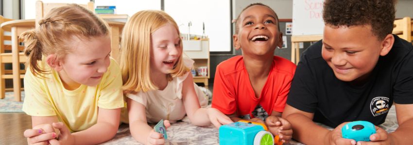 School-age children playing with a robot as a summer camp STEAM activity